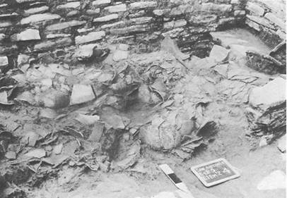 
						Material quemado y fragmentos de cerámica en la parte meridional del baño de vapor de San Antonio (según Agrinier, 1969: 25).
					