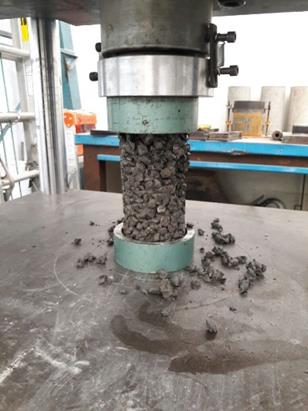 
								Cilindro de concreto permeable sometido a compresión.
							